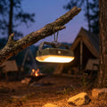 AuraGlow Retro Lantern glowing warm light hanging on tree branch at campsite
